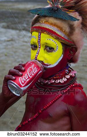 "Colourfully decorated and painted boy drinking from a Coke can during the traditional Sing Sing in the highlands, Enga, Highlands, Papua New Guinea, Oceania" View Large Photo Image Stock Image - "Colourfully decorated and painted boy drinking from a Coke can during the traditional Sing Sing in the highlands, Enga, Highlands, Papua New Guinea, Oceania". Fotosearch