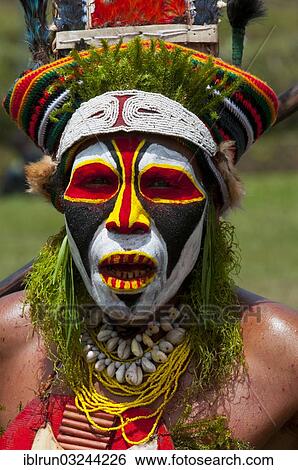 Stock Photograph - "Colourfully decorated and painted man celebrating the traditional Sing Sing in the highlands, Enga, Highlands, Papua New Guinea, Oceania". Fotosearch