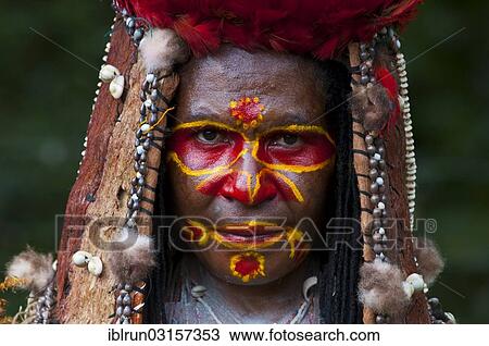 Stock Image - "Colourfully decorated woman with face paint is celebrating at the traditional Sing Sing gathering in the highlands, Paya, Papua New Guinea, Oceania". Fotosearch