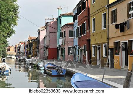 Stock Image - "Colourfully painted houses, boats in the canal of Burano, Burano, island in the Venetian Lagoon, Venice, Veneto, Italy, Europe". Fotosearch