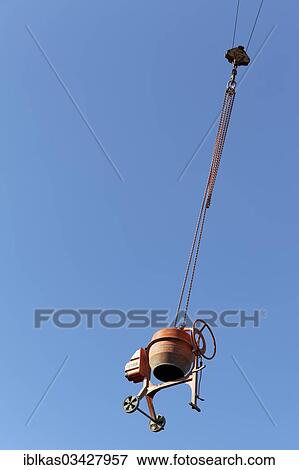 "Concrete mixer hanging from a crane, theft protection on a construction site" View Large Photo Image Stock Photo - "Concrete mixer hanging from a crane, theft protection on a construction site". Fotosearch