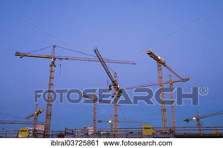 Stock Image - "Construction cranes on the construction site of the Milaneo at dusk, Stuttgart, Baden-Wurttemberg, Germany, Europe". Fotosearch
