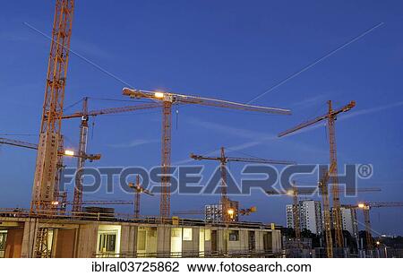 Stock Image - "Construction cranes on the construction site of the Milaneo at dusk, Stuttgart, Baden-Wurttemberg, Germany, Europe". Fotosearch