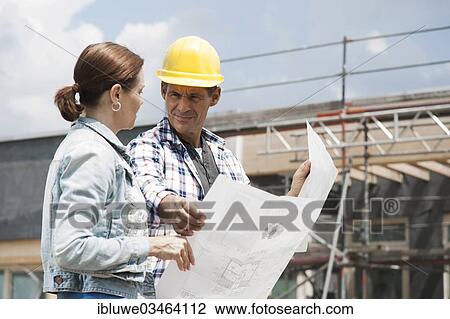 Stock Image - "Construction manager and building owner discussing plans on a construction site, Mannheim, Baden-Wurttemberg, Germany, Europe". Fotosearch