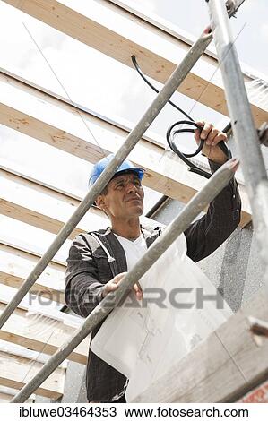 Stock Image - "Construction manager controlling the electrical wiring on a construction site, Mannheim, Baden-Wurttemberg, Germany, Europe". Fotosearch