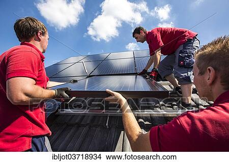 Picture - "Construction of a solar energy system on a house, installation of solar panels on a pitched roof, Bottrop, Ruhr district, North Rhine-Westphalia, Germany, Europe". Fotosearch