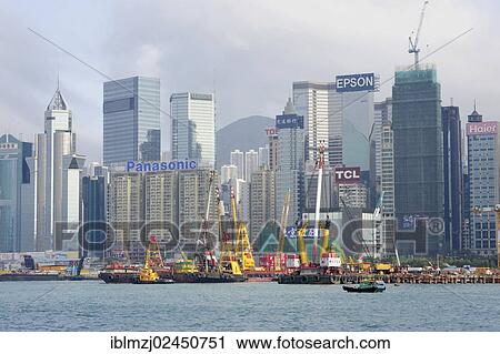 Stock Image - "Construction site at the harbour, Victoria Harbour, the skyline with skyscrapers at the back, Wan Chai, Hong Kong Island, Hong Kong, China, Asia". Fotosearch