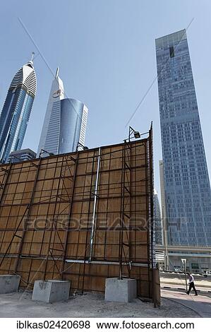 Construction site with a wooden partition in front of the skyline, Sheikh Zayed Road, Dubai International Financial Centre, DIFC, Dubai, United Arab Emirates, Middle East, Asia View Large Photo Image Stock Photo - Construction site with a wooden partition in front of the skyline, Sheikh Zayed Road, Dubai International Financial Centre, DIFC, Dubai, United Arab Emirates, Middle East, Asia. Fotosearch