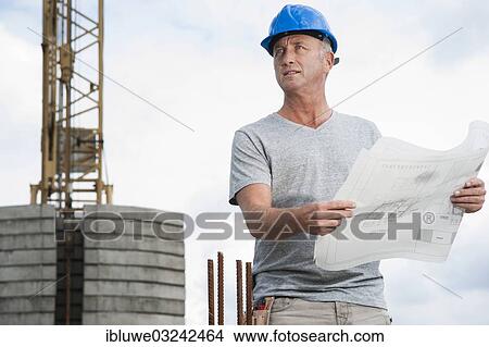 "Construction worker wearing a hard hat and holding a building plan, Mannheim, Baden-Wurttemberg, Germany, Europe" View Large Photo Image Picture - "Construction worker wearing a hard hat and holding a building plan, Mannheim, Baden-Wurttemberg, Germany, Europe". Fotosearch
