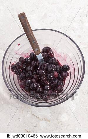 Stock Photography - Cooked blueberries in a glass bowl with spoon. Fotosearch