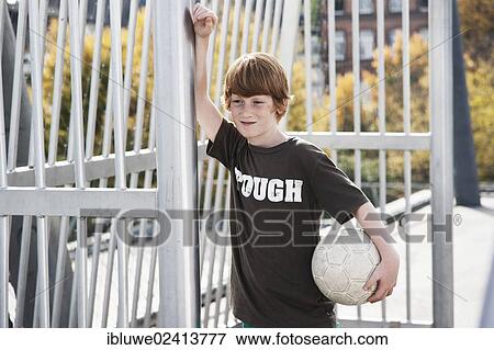 Cool boy holding a football View Large Photo Image Stock Photo - Cool boy holding a football. Fotosearch