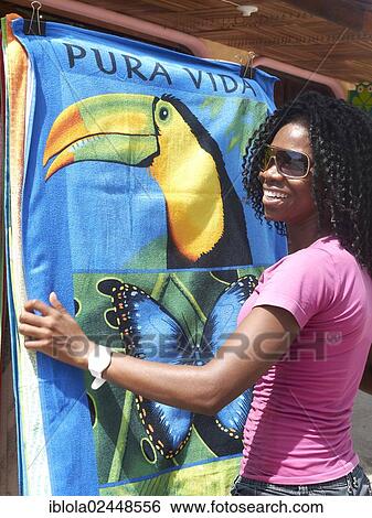 "Costa Rican woman, 35, in a souvenir shop with a bath towel with the message Pura Vida, Playa Samara, Nicoya Peninsula, Costa Rica, Central America, North America" View Large Photo Image Stock Photograph - "Costa Rican woman, 35, in a souvenir shop with a bath towel with the message Pura Vida, Playa Samara, Nicoya Peninsula, Costa Rica, Central America, North America". Fotosearch