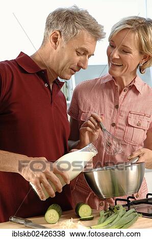 Stock Photo - "Couple, 35-45, in love, cooking in a kitchen". Fotosearch