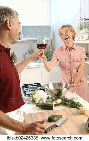 "Couple, 35-45, in love, cooking in a kitchen, clinking glasses with red wine" View Large Photo Image Stock Photography - "Couple, 35-45, in love, cooking in a kitchen, clinking glasses with red wine". Fotosearch