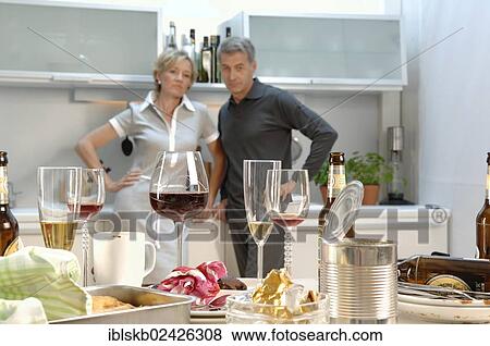 "Couple, 35-45, standing together in a messy kitchen after a party" View Large Photo Image Stock Photo - "Couple, 35-45, standing together in a messy kitchen after a party". Fotosearch