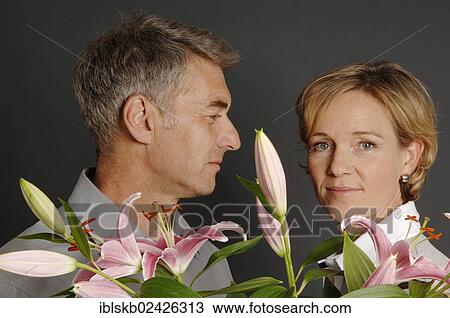 "Couple, 35-45, standing together with flowers in the foreground" View Large Photo Image Stock Image - "Couple, 35-45, standing together with flowers in the foreground". Fotosearch