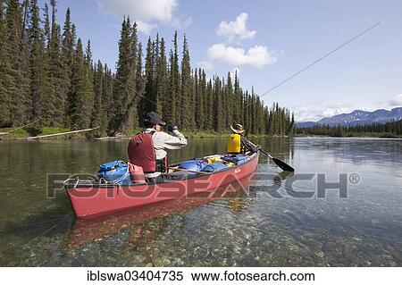 Stock Photography - "couple, man and woman paddling a canoe, canoing, upper Liard River, Yukon Territory, Yukon Territory, Canada, North America". Fotosearch