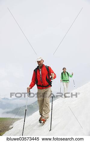 "Couple moving over a snow field during their hike to Mt. Neunerkoepfle, Neunerkopfle, Tannheim Valley, Tyrol, Austria, Europe" View Large Photo Image Stock Photography - "Couple moving over a snow field during their hike to Mt. Neunerkoepfle, Neunerkopfle, Tannheim Valley, Tyrol, Austria, Europe". Fotosearch