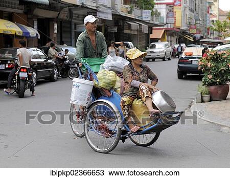 Stock Image - "Couple on a tricycle, Phnom Penh, Cambodia, Southeast Asia, Asia". Fotosearch
