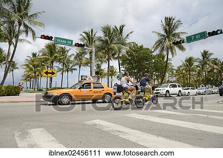 "Couple riding electric bicycles, Ocean Drive, South Beach, Miami, Florida, USA" View Large Photo Image Stock Image - "Couple riding electric bicycles, Ocean Drive, South Beach, Miami, Florida, USA". Fotosearch