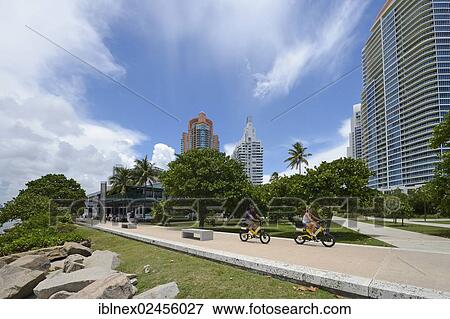 Stock Photo - "Couple riding electric bicycles, South Pointe Park, South Beach, Miami, Florida, USA". Fotosearch
