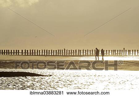 "Couple walking in front of groynes, in backlight, Wangerooge, East Frisian Islands, East Frisia, Lower Saxony, Germany, Europe" View Large Photo Image Stock Image - "Couple walking in front of groynes, in backlight, Wangerooge, East Frisian Islands, East Frisia, Lower Saxony, Germany, Europe". Fotosearch
