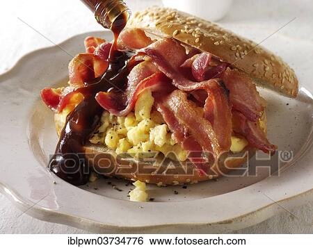 Crispy streaky bacon and scrambled eggs on a bagel with brown sauce View Large Photo Image Stock Photograph - Crispy streaky bacon and scrambled eggs on a bagel with brown sauce. Fotosearch