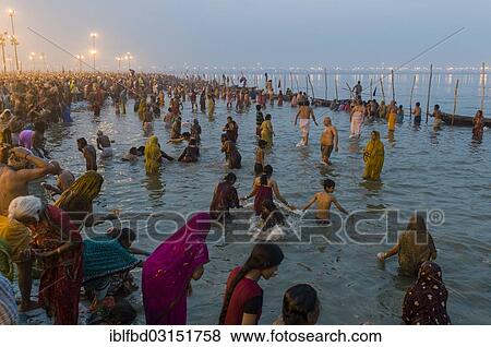 Stock Photo - "Crowds of people gathering on the Sangam, the confluence of the rivers Ganges, Yamuna and Saraswati, for the holy bath in the early morning, Kumbha Mela mass Hindu pilgrimage, Allahabad, Uttar Pradesh, India, Asia". Fotosearch
