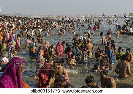 Stock Image - "Crowds of people taking a bath in the Sangam, the confluence of the rivers Ganges, Yamuna and Saraswati, Kumbha Mela mass Hindu pilgrimage, Allahabad, Uttar Pradesh, India, Asia". Fotosearch