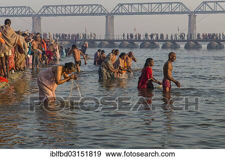 Stock Photo - "Crowds of people taking a bath in the Sangam, the confluence of the rivers Ganges, Yamuna and Saraswati, in the early morning, Kumbha Mela mass Hindu pilgrimage, Allahabad, Uttar Pradesh, India, Asia". Fotosearch