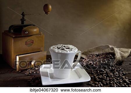 Cup of cappuccino with coffee beans and an old coffee grinder View Large Photo Image Stock Image - Cup of cappuccino with coffee beans and an old coffee grinder. Fotosearch