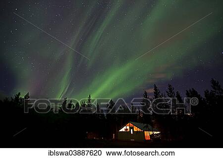 Stock Image - "Curtains of northern polar lights and iluminated cabin, wall tent, near Whitehorse, Yukon Territory, Canada, North America". Fotosearch