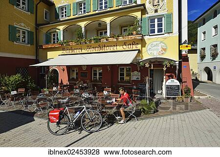 "Cyclist having a break outside Cafe Cupido in Marktschellenberg, Berchtesgaden, Upper Bavaria, Bavaria, Germany, Europe" View Large Photo Image Stock Photo - "Cyclist having a break outside Cafe Cupido in Marktschellenberg, Berchtesgaden, Upper Bavaria, Bavaria, Germany, Europe". Fotosearch