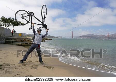 "Cyclist holding his bike above his head, Golden Gate Bridge at the back, San Francisco, California, USA" View Large Photo Image Stock Photo - "Cyclist holding his bike above his head, Golden Gate Bridge at the back, San Francisco, California, USA". Fotosearch