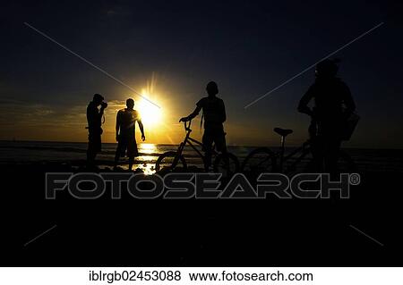 "Cyclist, photographer and bathers at sunset on the beach in Playa de las Americas, Tenerife, Canary Islands, Spain, Europe" View Large Photo Image Stock Photo - "Cyclist, photographer and bathers at sunset on the beach in Playa de las Americas, Tenerife, Canary Islands, Spain, Europe". Fotosearch