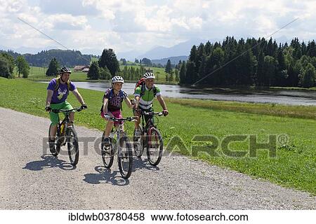"Cyclists on bike tour on Luimooser Weiher pond in Seeg, Ostallgaeu, Swabia, Bavaria, Germany, Europe" View Large Photo Image Stock Photo - "Cyclists on bike tour on Luimooser Weiher pond in Seeg, Ostallgaeu, Swabia, Bavaria, Germany, Europe". Fotosearch