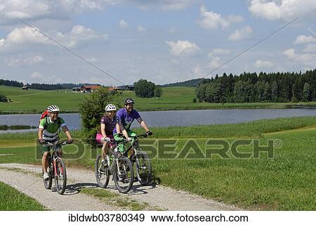 "Cyclists on bike tour on Trollweiher pond in Seeg, Ostallgaeu, Swabia, Bavaria, Germany, Europe" View Large Photo Image Stock Photo - "Cyclists on bike tour on Trollweiher pond in Seeg, Ostallgaeu, Swabia, Bavaria, Germany, Europe". Fotosearch