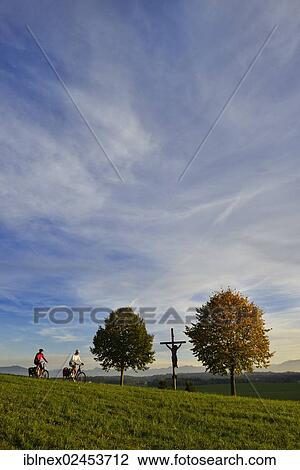 Stock Image - "Cyclists riding electric bicycles near Spanswag, Koestendorf, Lake Waller, Salzburg Lake District, Salzburg, Austria, Europe". Fotosearch