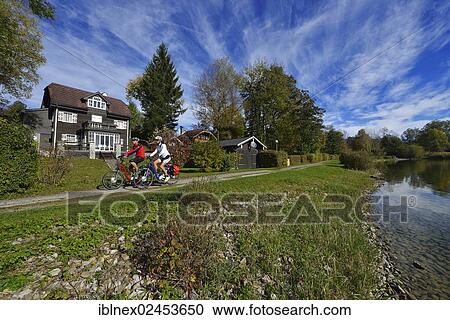 Stock Image - "Cyclists riding electric bicycles, Matzing, Lake Waller, Neumarkt, Salzburg Lake District, Salzburg, Austria, Europe". Fotosearch