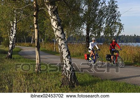 "Cyclists riding electric bicycles along Bajuwaren Cycle Route, Fraham, Lake Grabensee, Salzburg Lake District, Salzburg, Austria, Europe" View Large Photo Image Stock Image - "Cyclists riding electric bicycles along Bajuwaren Cycle Route, Fraham, Lake Grabensee, Salzburg Lake District, Salzburg, Austria, Europe". Fotosearch