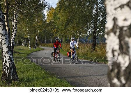 Stock Photography - "Cyclists riding electric bicycles along Bajuwaren Cycle Route, Fraham, Lake Grabensee, Salzburg Lake District, Salzburg, Austria, Europe". Fotosearch