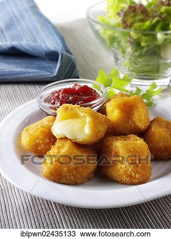 Stock Image - Deep fried camembert in bread crumbs with salad. Fotosearch
