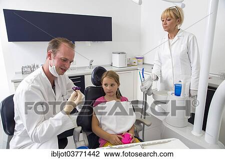"Dentist discussing further treatment with a girl and showing her braces, Germany, Europe" View Large Photo Image Stock Image - "Dentist discussing further treatment with a girl and showing her braces, Germany, Europe". Fotosearch