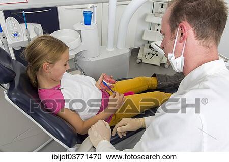 "Dentist showing a girl the proper use of a toothbrush, Germany, Europe" View Large Photo Image Stock Image - "Dentist showing a girl the proper use of a toothbrush, Germany, Europe". Fotosearch