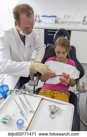 "Dentist showing a girl the proper use of a toothbrush, Germany, Europe" View Large Photo Image Stock Image - "Dentist showing a girl the proper use of a toothbrush, Germany, Europe". Fotosearch