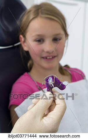 "Dentist showing braces to a girl, Germany, Europe" View Large Photo Image Picture - "Dentist showing braces to a girl, Germany, Europe". Fotosearch