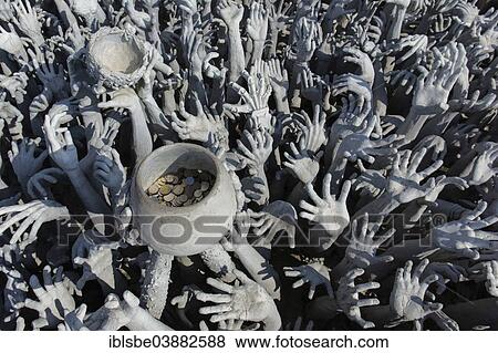 Stock Photo - "Depiction of hell, hands pleading for help and a begging bowl, at Wat Rong Khun, bridge to the entrance of the White Temple, by architect Chalermchai Kositpipat, Chiang Rai, Chiang Rai Province, Northern Thailand, Thailand, Asia". Fotosearch