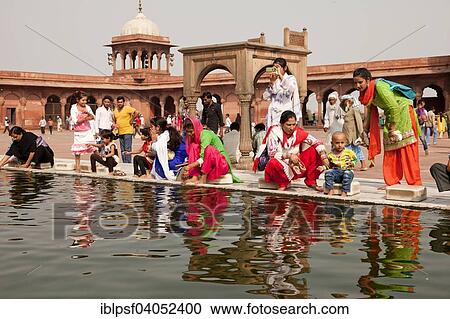 Stock Image - "Devout Muslims purifying themselves in the water basin of the Friday Mosque Jama Masjid, Delhi, India, Asia". Fotosearch