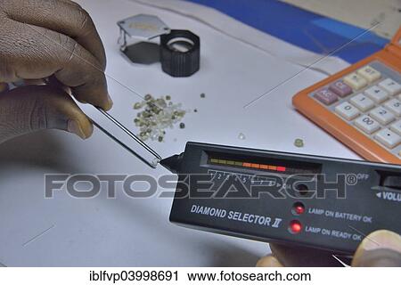 "Diamond dealer inspecting a diamond for its authenticity, Koidu, Koidu-Sefadu, Kono District, Eastern Province, Sierra Leone, Africa" View Large Photo Image Stock Image - "Diamond dealer inspecting a diamond for its authenticity, Koidu, Koidu-Sefadu, Kono District, Eastern Province, Sierra Leone, Africa". Fotosearch