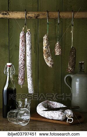 Different varieties of salami sausages hanging in front of a green wooden wall View Large Photo Image Stock Image - Different varieties of salami sausages hanging in front of a green wooden wall. Fotosearch
